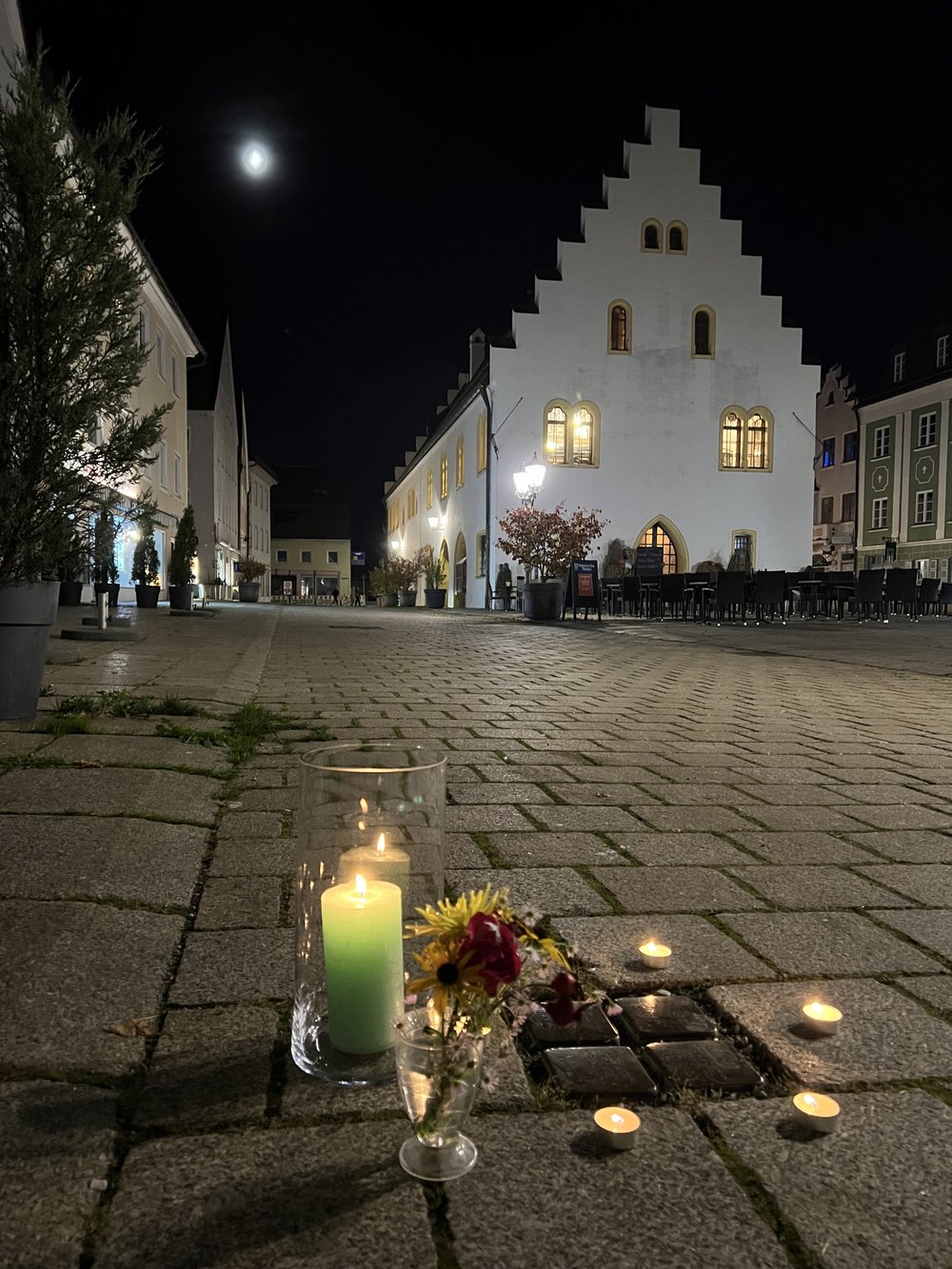 Kerzen und Blumen an den Stolpersteinen am Schongauer Marienplatz